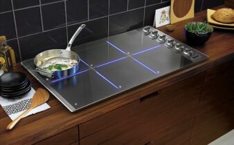 Moderne inductiekookplaat met pan op een houten keukenblad