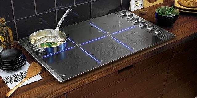 Moderne inductiekookplaat met pan op een houten keukenblad