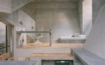 Brutalistisch interieur met betonnen muren, houten vloer en bed