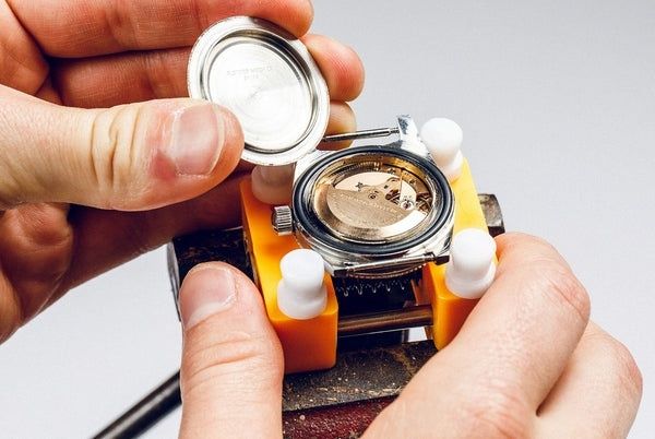 Horlogemaker opent een automatisch horloge met zichtbaar uurwerk